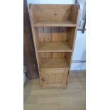 A new pine bookcase with a base cupboard 110cm tall, 39 x 23cm