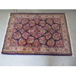 A small hand knotted woolen rug with a blue field 150cm x 108cm generally good condition, some