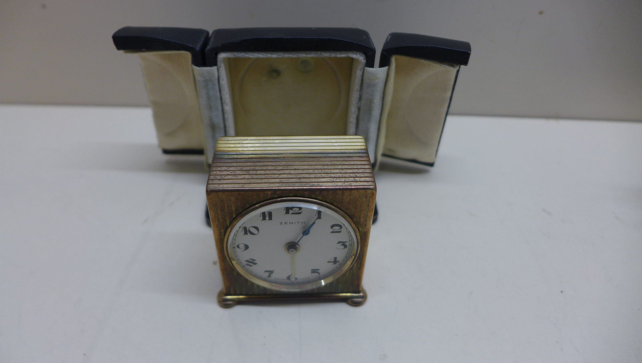 A Zenith travel alarm clock with outer case with a 4cm dial, running in saleroom.