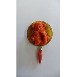 A 9ct yellow gold carved coral brooch with a coral drop, 6.5cm x 4cm. In good condition, approx 20