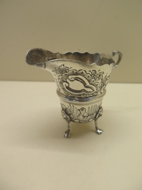 An ornate embossed silver cream jug. 10 cm tall approx 3.4 troy oz. Hallmark Birmingham 1972-73 HIE. - Image 3 of 4