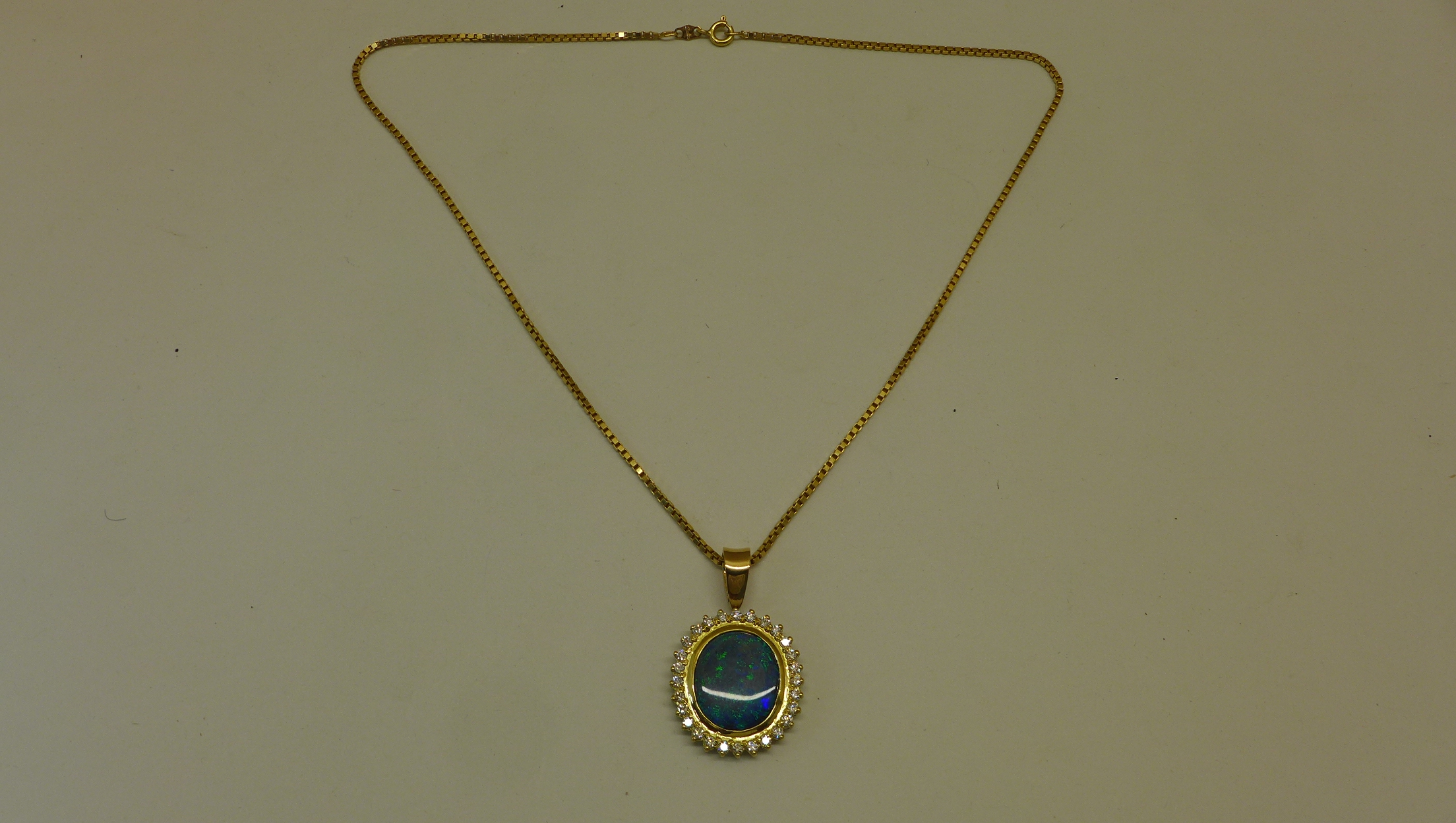 A reversible black opal and diamond pendant set in 18ct yellow gold on an 18ct chain, chain length
