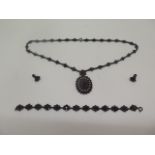 A bohemian white metal garnet and pearl necklace with bracelet and earrings. all generally good