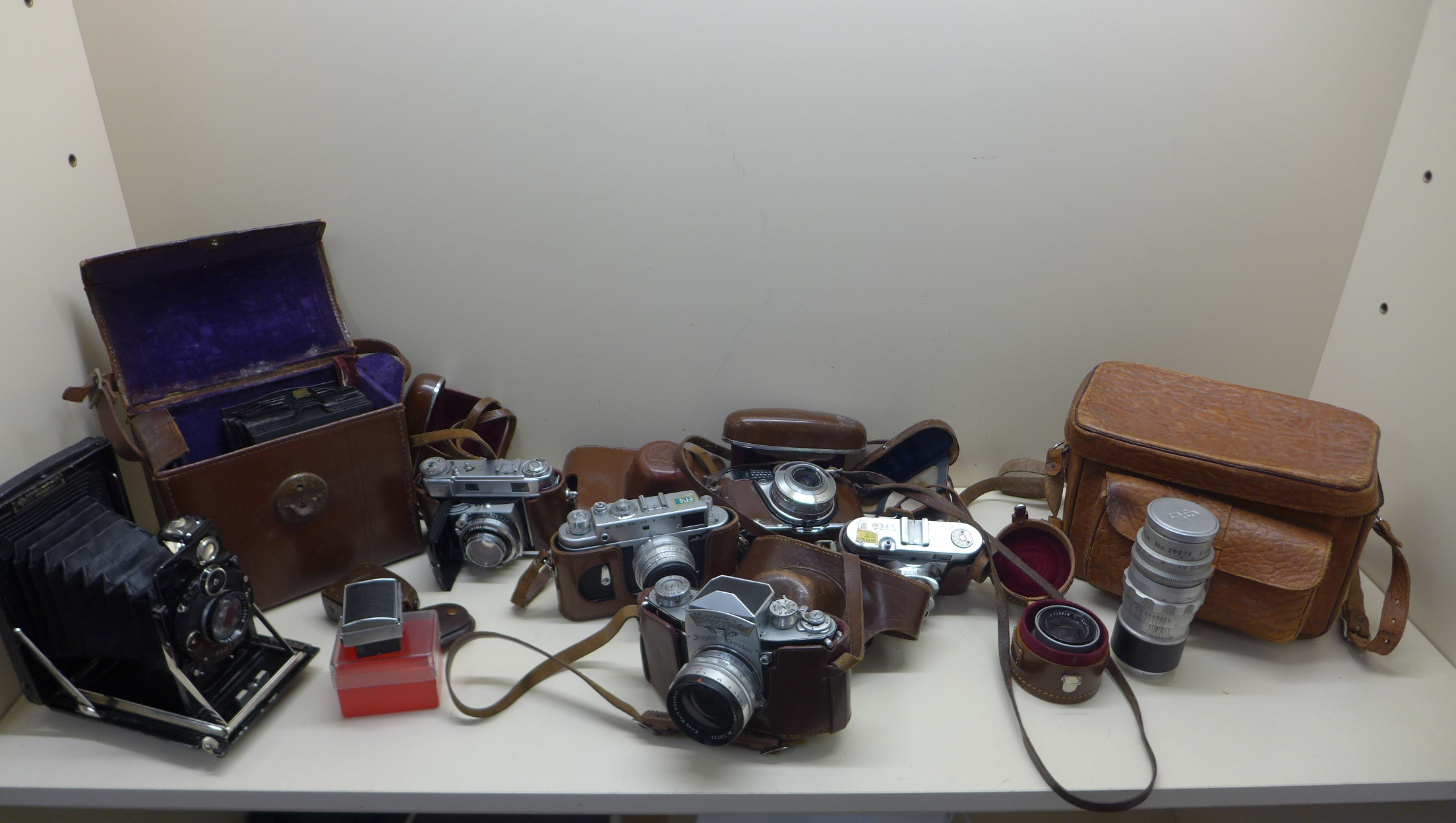 A Kamera-Werkstatten folding bellows plate camera with case, a Zorki-4 camera, Voigt lander