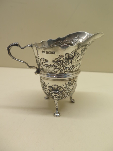 An ornate embossed silver cream jug. 10 cm tall approx 3.4 troy oz. Hallmark Birmingham 1972-73 HIE.