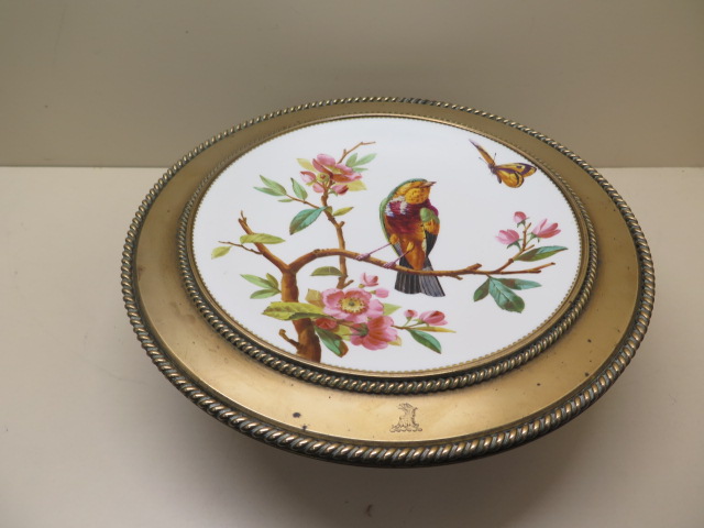 A 19th century bird decorated bronze and porcelain tazza with a crest, 10cm tall x 33cm diameter