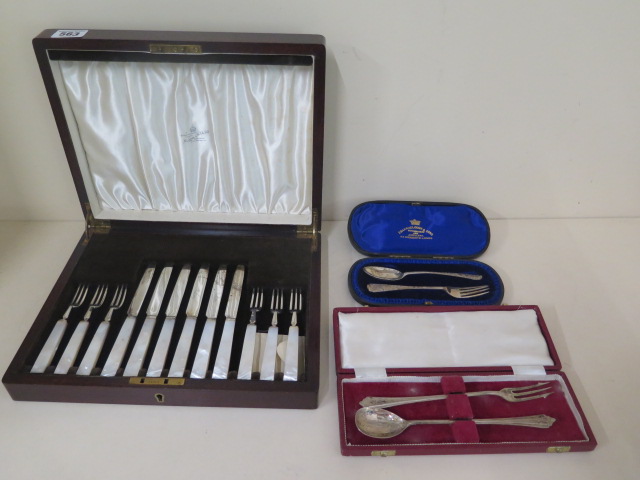 Two boxed silver fork and spoon sets and a boxed silver and mother of pearl cake and fork set.