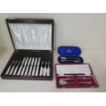 Two boxed silver fork and spoon sets and a boxed silver and mother of pearl cake and fork set.