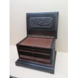 A carved and ebonised humidor with 4 slides and a drawer, one slide repaired otherwise generally