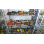 A large quantity of O gauge tin plate railway rolling stock including some buildings and locos.