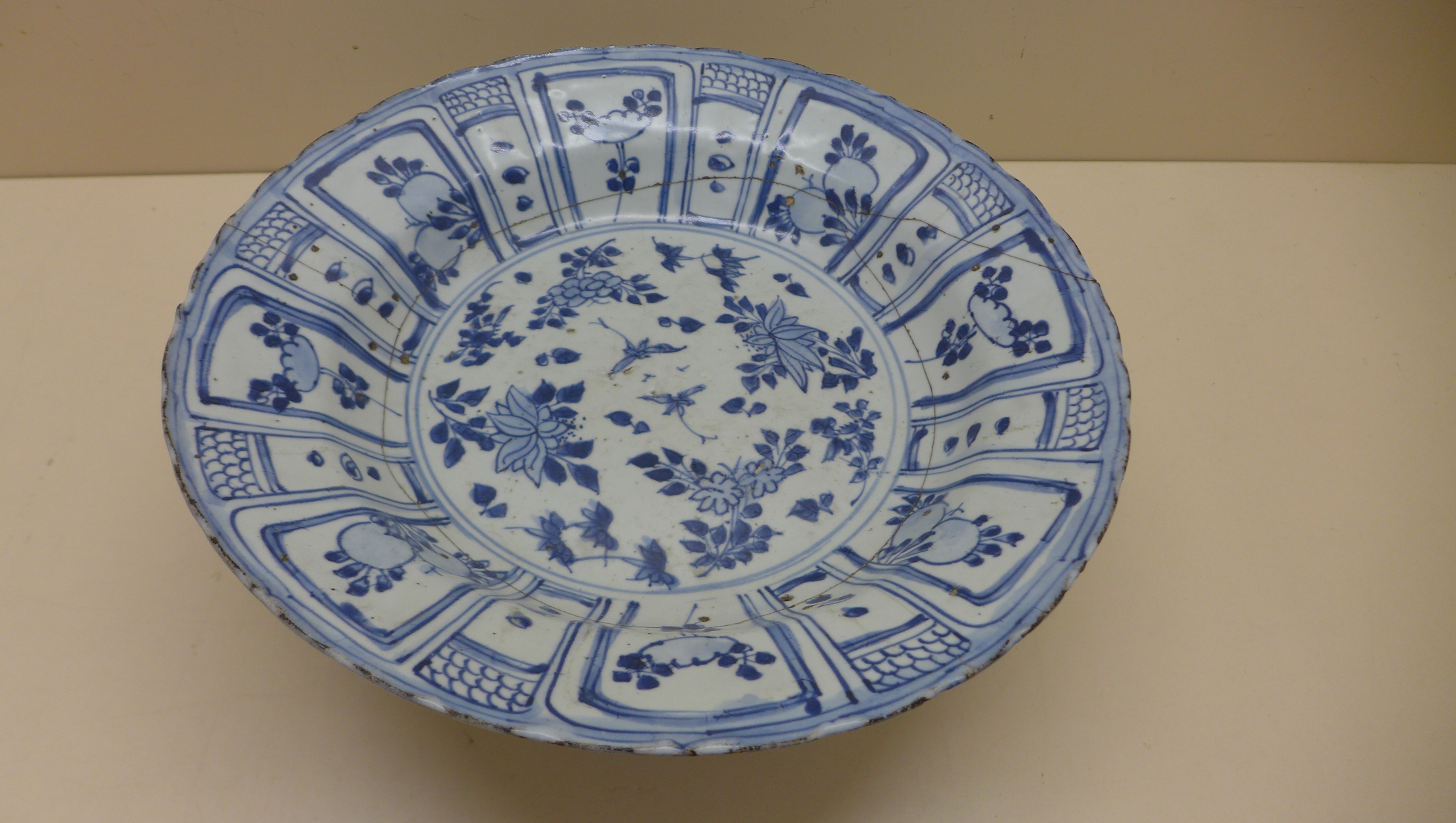 An oriental blue and white fruit and foliate decorated bowl. 5 cm tall x 27.5 cm wide on an