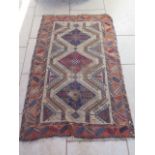 A hand knotted woollen rug with geometric design, 195cm x 120cm, overall wear. Removed from a