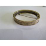 An unhallmarked gold bangle, tests to approx 14ct, 6cm x 5cm, total weight approx 13 grams, safety