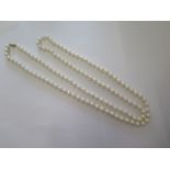 A long string of pearls with a 9ct gold clasp, 115cm long, pearls approx 7mm diameter generally good