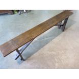 An early 20th century long pine (date stamped 1915) folding bench 52 cm tall , 174 long , 22 deep