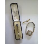 A pin marked 15ct, a broken 9ct brooch and a 9ct gold manual wind wristwatch on a plated strap,