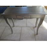 A silver painted side table with a drawer, 86 cm tall x 100 cm x 40 cm
