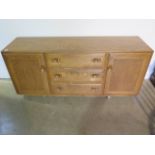 An Ercol blond elm sideboard with 3 drawers and 2 cupboard doors, 67cm tall, 156cm x 43cm, in good
