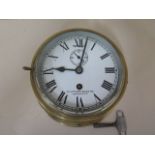 A circular brass ships timepiece by Lilley and Reynolds Ltd, London, white dial, seconds and slow/