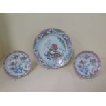 A pair of famille rose saucers and a plate, saucers 13cm diameter, plate 22cm diameter, all in