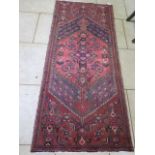 A hand knotted woollen rug, 222cm x 95cm