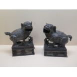 A pair of bronze dogs of Fo, 22cm tall x 20cm long, generally good with good patina, firing crack to
