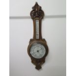 A carved oak aneroid barometer, 90cm long
