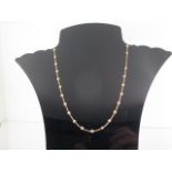 A diamond set chain necklet comprising of a length of rounded yellow trace link chain interspread