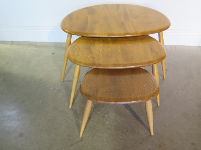 An Ercol blonde elm nest of 3 pebble tables, repair to base of largest otherwise good condition