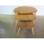 An Ercol blonde elm nest of 3 pebble tables, repair to base of largest otherwise good condition