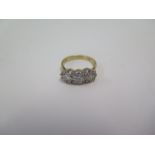 A hallmarked 18ct gold three stone diamond ring, central illusion set diamond approx 0.26ct, ring