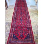 A hand knotted woollen Hamadan runner, 4.37m x 1.07m, some wear but colours bright
