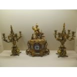 A Louis XVI style gilt metal mantel clock with a figural surmount and inset painted porcelain dial