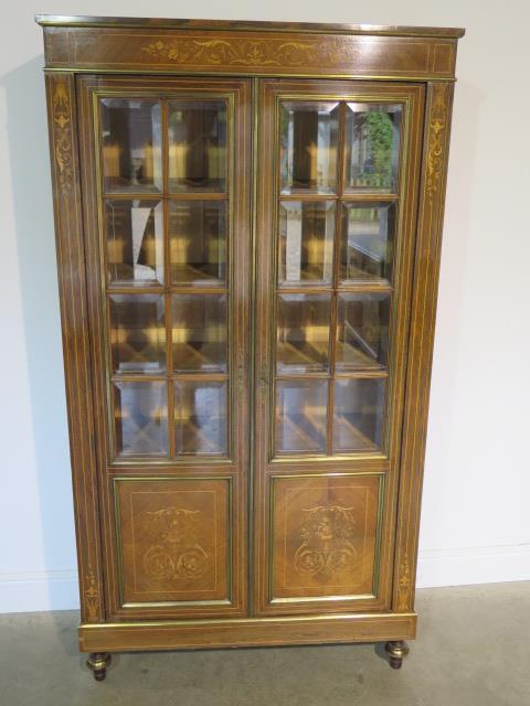 A French 19th century rosewood inlaid bookcase, the glazed doors opening to reveal five internal