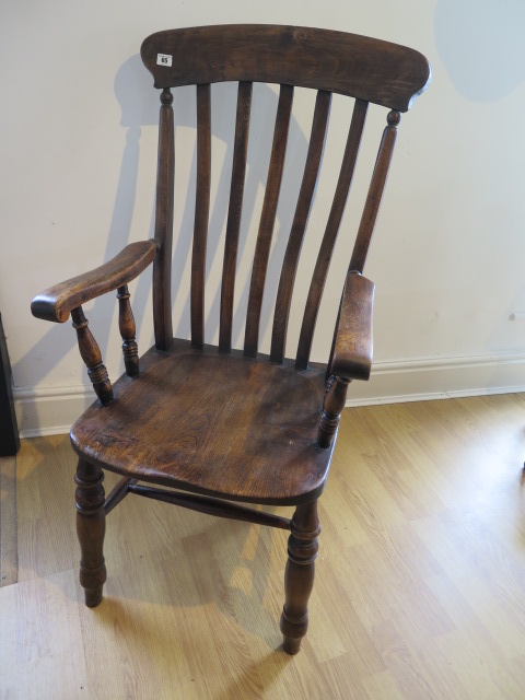 A 19th century ash and elm elbow chair, some movement to joints and old worm but a good colour