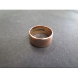A hallmarked 9ct yellow gold band ring, size Q, 8mm deep, approx 7.8 grams, some usage marks but