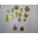 A collection of 14 French gold medallions and a brooch, 12 test to either 18ct or lower, 2 test to