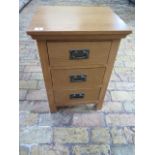 An oak three drawer bedside chest, some usage marks