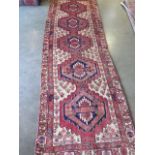 A hand knotted woollen Karajeh rug, 3.10m x 1m, some general wear colours good