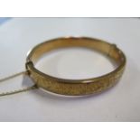 A hallmarked 9ct yellow gold engraved hollow hinged bangle, approx 14 grams, external dimensions 6.