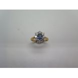 A hallmarked 18ct yellow gold sapphire and diamond cluster ring, the sapphire measures approx 6mm