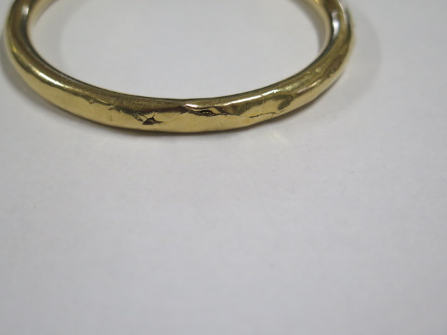 A yellow gold bangle tests to approx 18ct, approx 19.8 grams, 7.5cm external diameter, dented and - Image 2 of 3