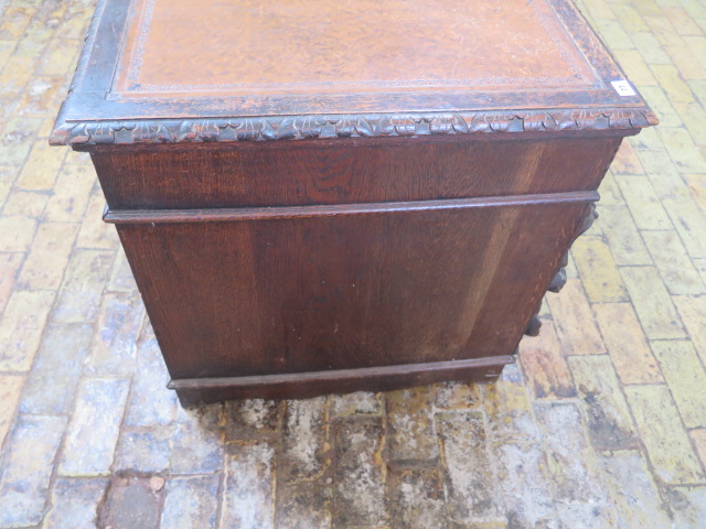 An oak kneehole writing desk with tooled leather top and ornate 'Green Man' carved drawers, 107cm - Image 5 of 6