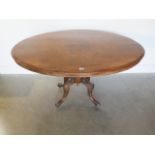 A Victorian walnut tilt top breakfast table on a carved quatrefoil base, 75cm tall x 133cm x