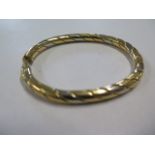 An 18ct tricolour gold hinged bangle, external dimensions 7cm x 5.6cm, weight approx 31.2 grams,