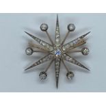 A stunning yellow gold diamond star pendant brooch, the central diamond approx 0.46ct, with six