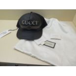 A Gucci black leather baseball cap with labels and dust bag, unworn, small mark to bag