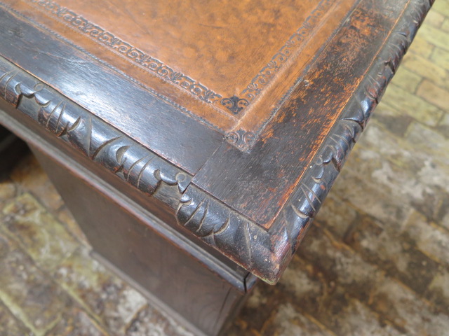 An oak kneehole writing desk with tooled leather top and ornate 'Green Man' carved drawers, 107cm - Image 4 of 6