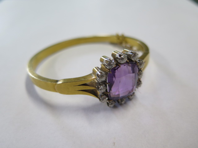 An impressive continental gold Amethyst and diamond hinged bangle, the central Amethyst is approx