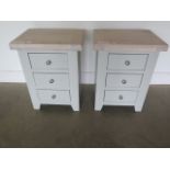 A pair of painted three drawer bedside chests with chalked oak tops, 62cm high x 47cm wide, ex-